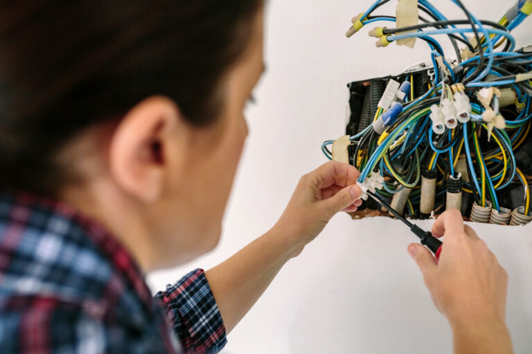 Un électricien raccorde plusieurs fils électriques dans un domino