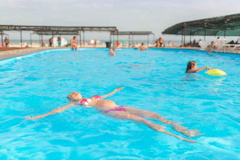 Une femme enceinte qui se baigne dans une piscine avec une plage immergé
