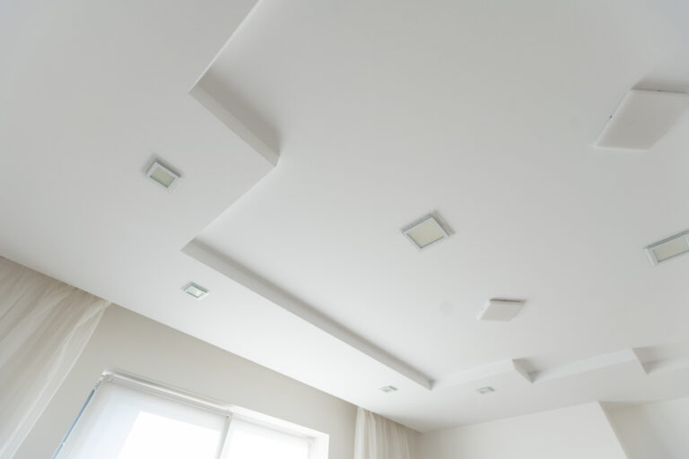 Un plafond en lattis-plâtre blanc avec des ampoules fixés avec