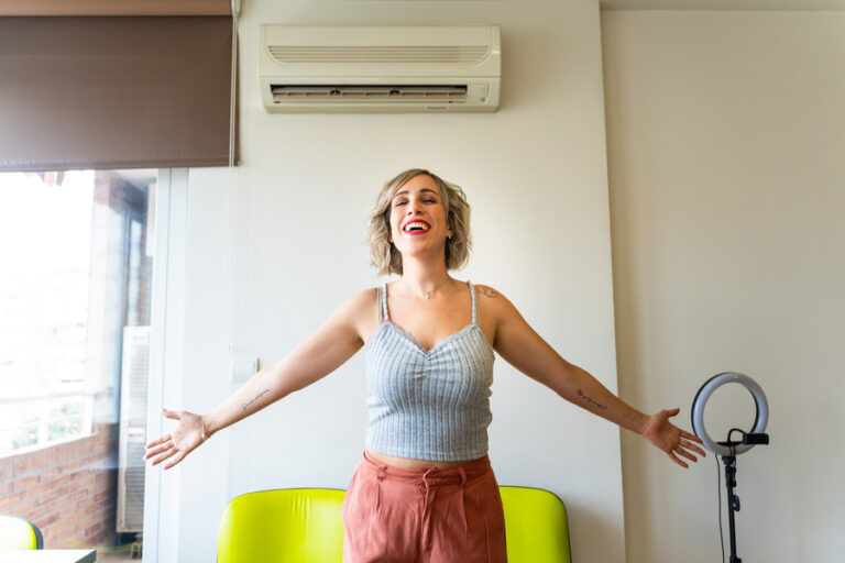 Une femme heureuse en profitant de sa pompe à chaleur air-air