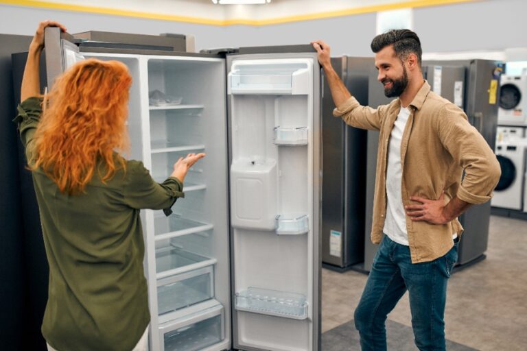 Réfrigérateur-congélateur moderne à deux portes avec deux moteurs, intérieur bien éclairé et rangements organisés