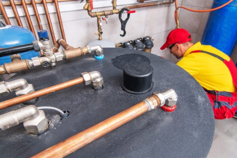 Un ballon d’eau chaude présente une fuite rouillée à la base de la cuve
