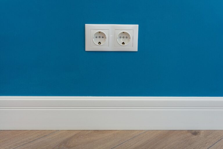 Des prises électriques design intégrées sur un mur coloré, contrastant avec la peinture pour un effet décoratif