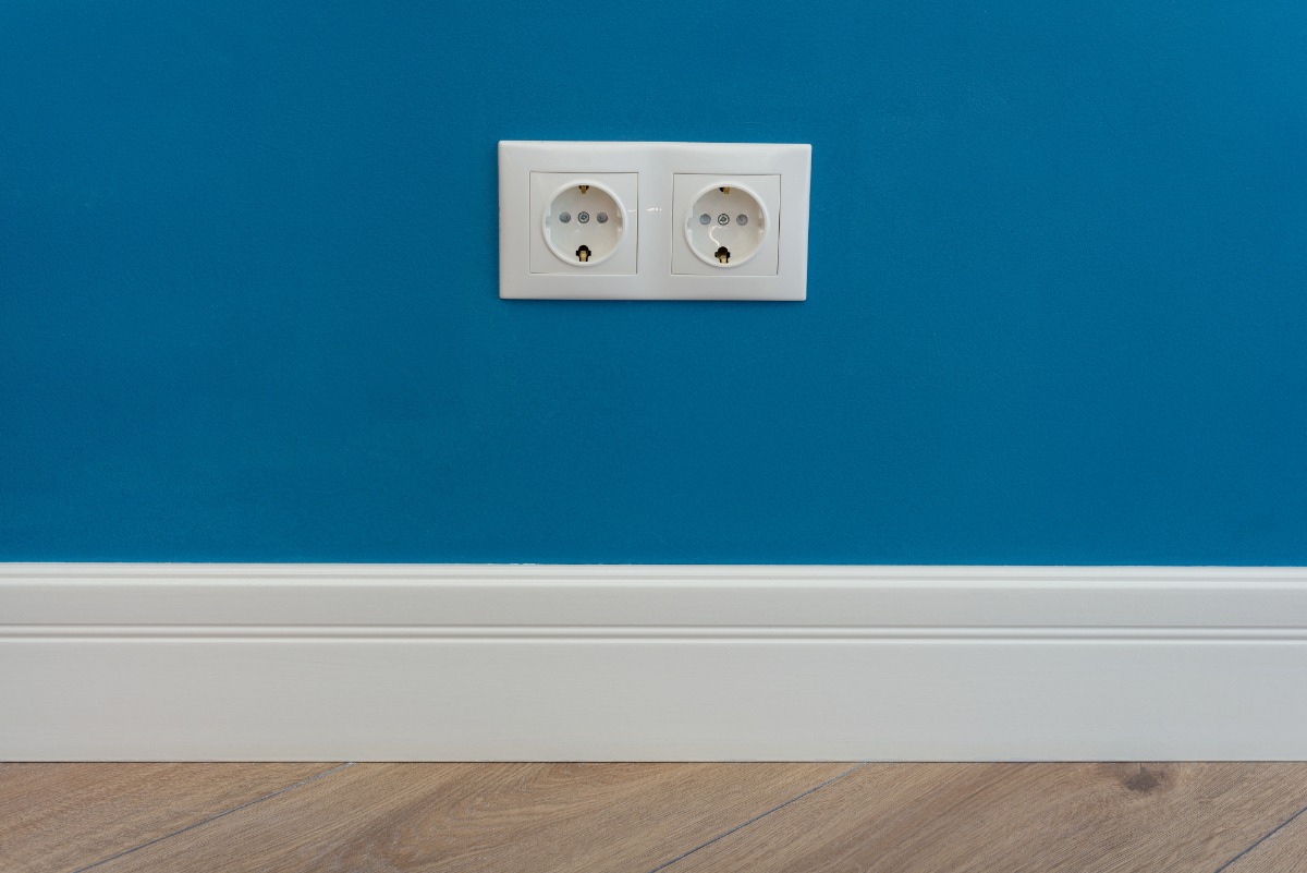 Des prises électriques design intégrées sur un mur coloré, contrastant avec la peinture pour un effet décoratif