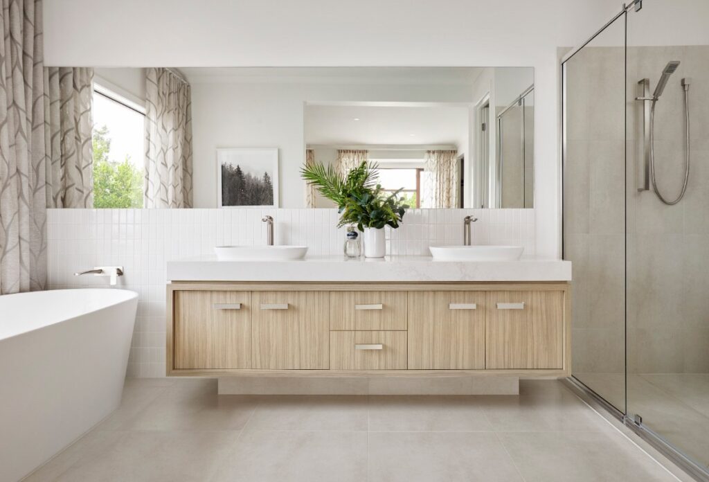 Une salle de bain lumineuse combine des matériaux haut de gamme, entre bois naturel, verre transparent et touches minérales