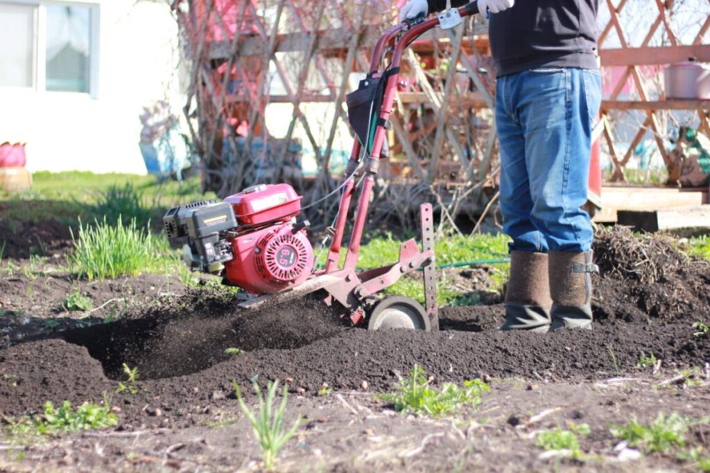 Un homme travaillant dans le jardin avec une motobineuse
