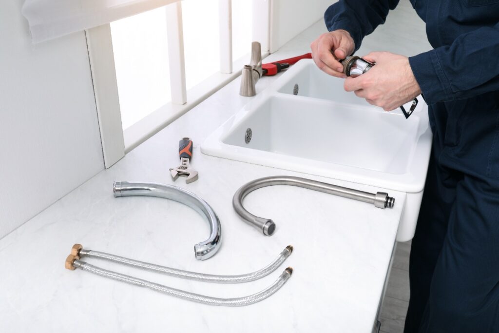 Un plombier réparant le joint d'un robinet col de cygne Grohe