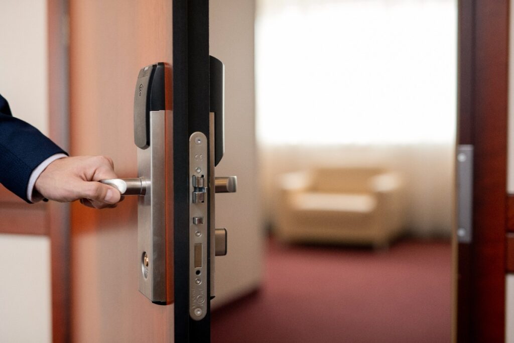 Main d'une personne fermant une porte d'un salon