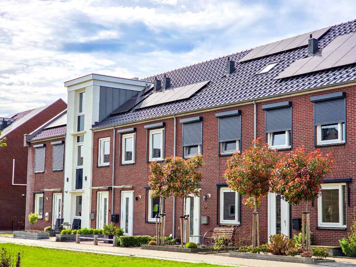 Maisons rénovées avec des panneaux solaires sur le toit et des volets roulants solaires installés pour les fenêtres
