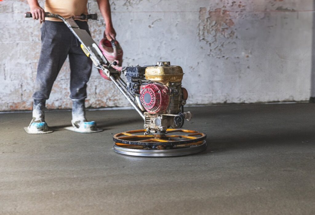 Un ouvrier réalisant un surfaçage de dalle en béton