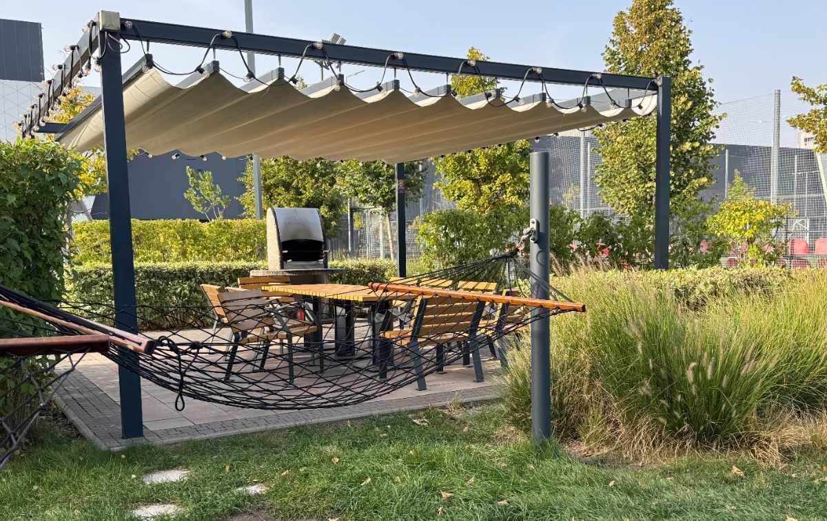 Une pergola dans le jardin avec un toit en bâche avec support en métal