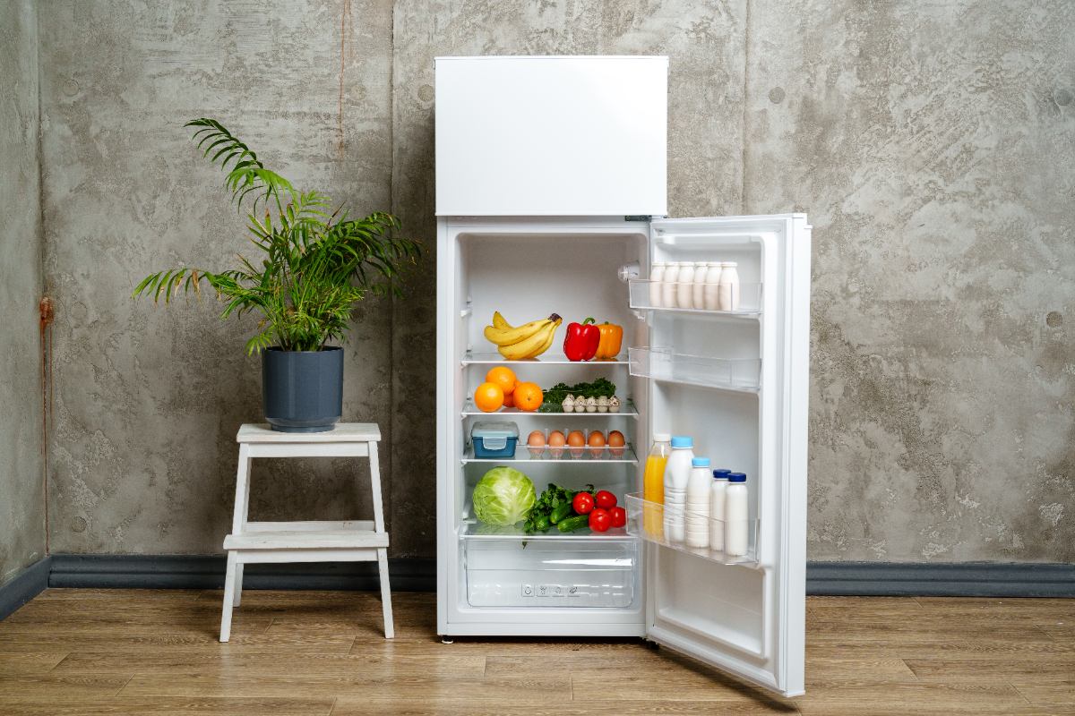 Un frigo avec une porte ouverte et pleine d'aliments dedans