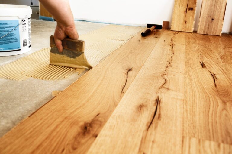Une personne qui réalise une pose de parquet