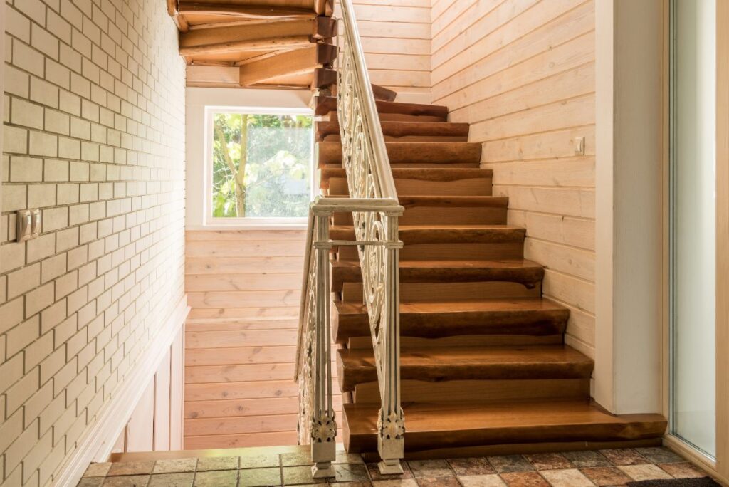Un escalier rustique avec une rampe blanche