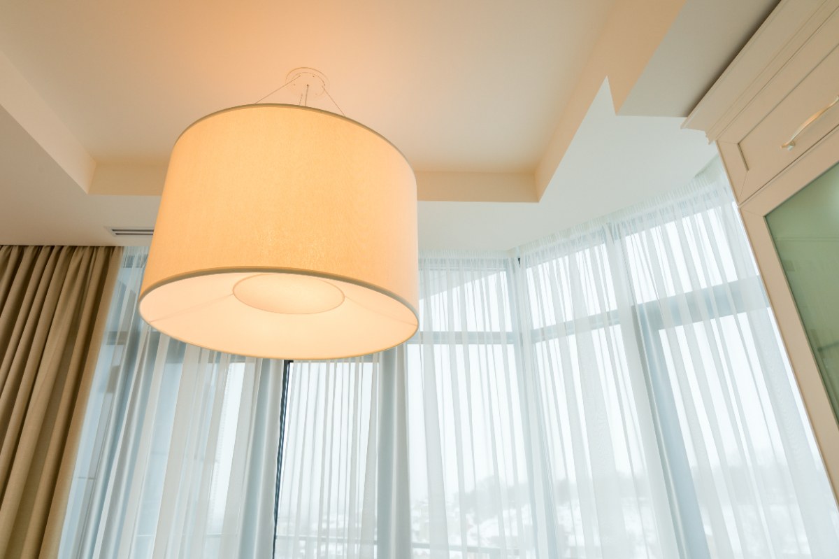 Une lampe élégante près de la fenêtre dans une pièce