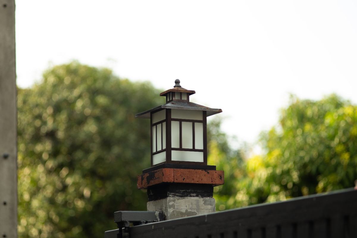 Une lampe installée sur le pilier d'un portail