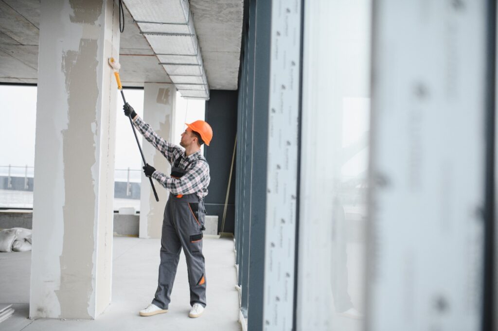 Un ouvrier de bâtiment peignant en béton
