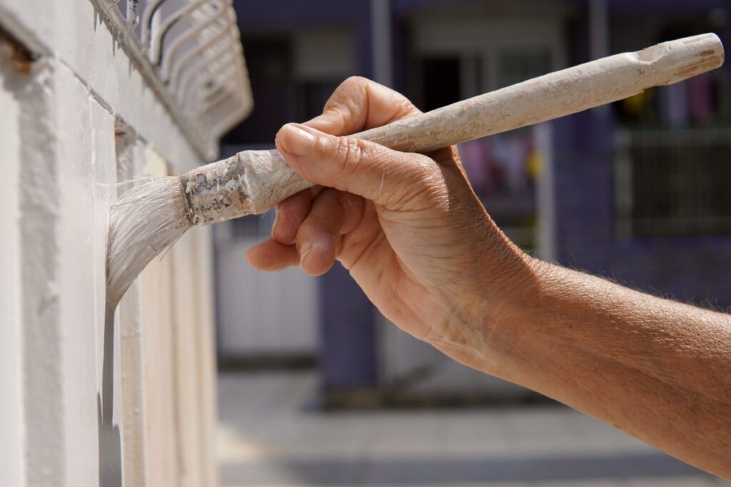 Une personne appliquant de la peinture sur du béton