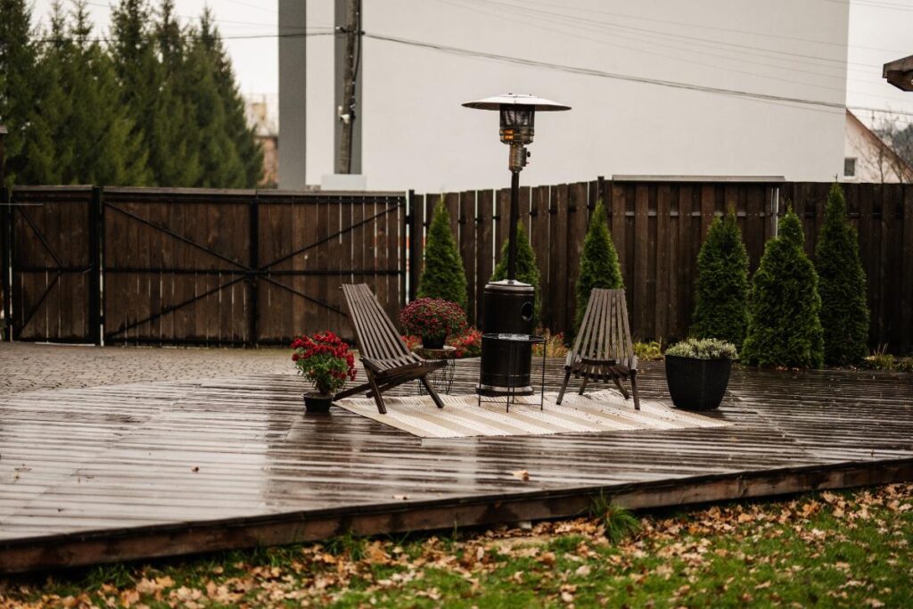Une terrasse en bois avec une chaise et des plantes dans des pots