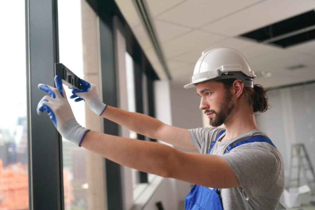 Un vitrier professionnel inspectant une fenêtre