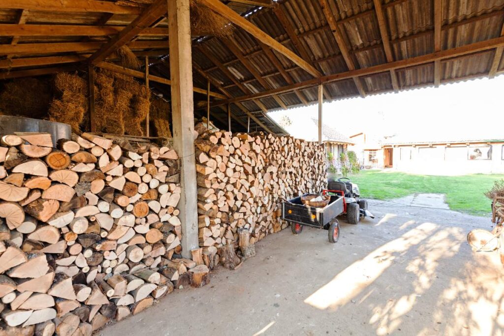 Des bois de chauffage stockés dans un abri en bois