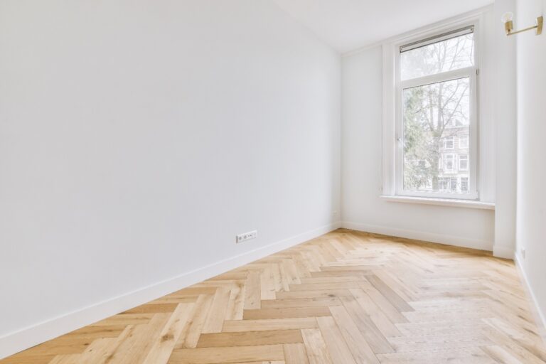 Une chambre lumineuse avec du sol en parquet