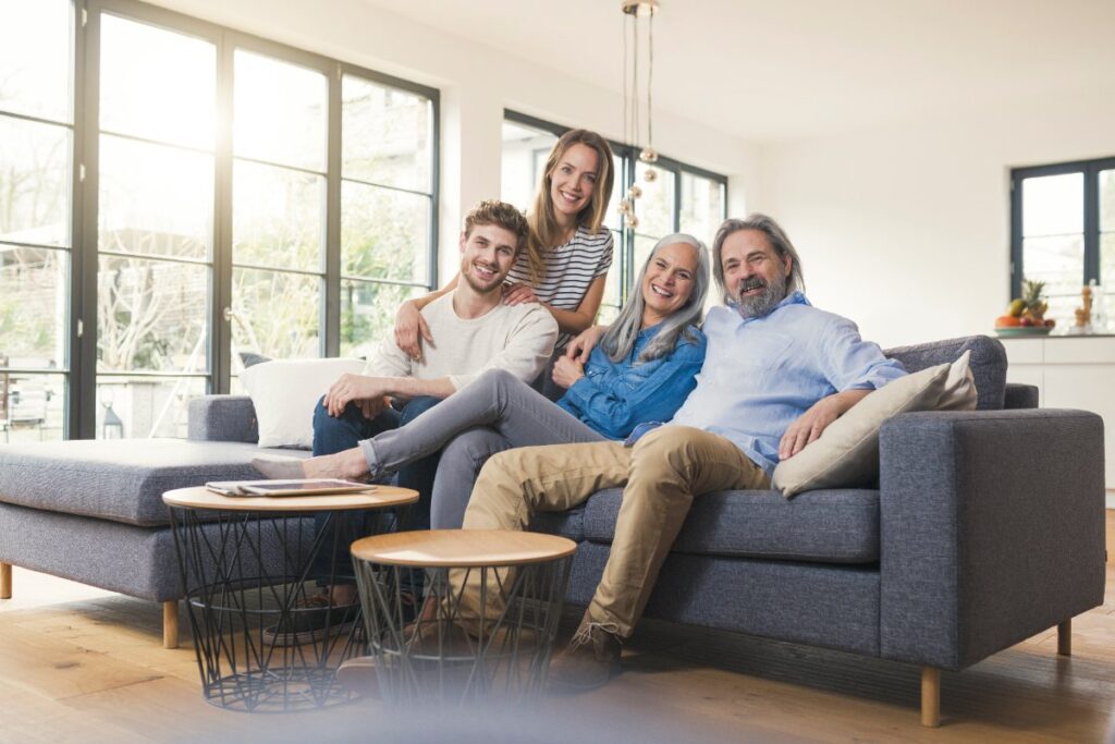 Une famille souriante se détendant ensemble sur un canapé