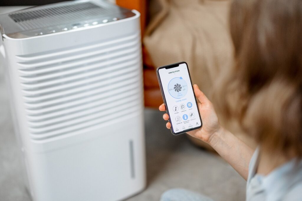Une femme utilisant un téléphone pour contrôler son climatiseur