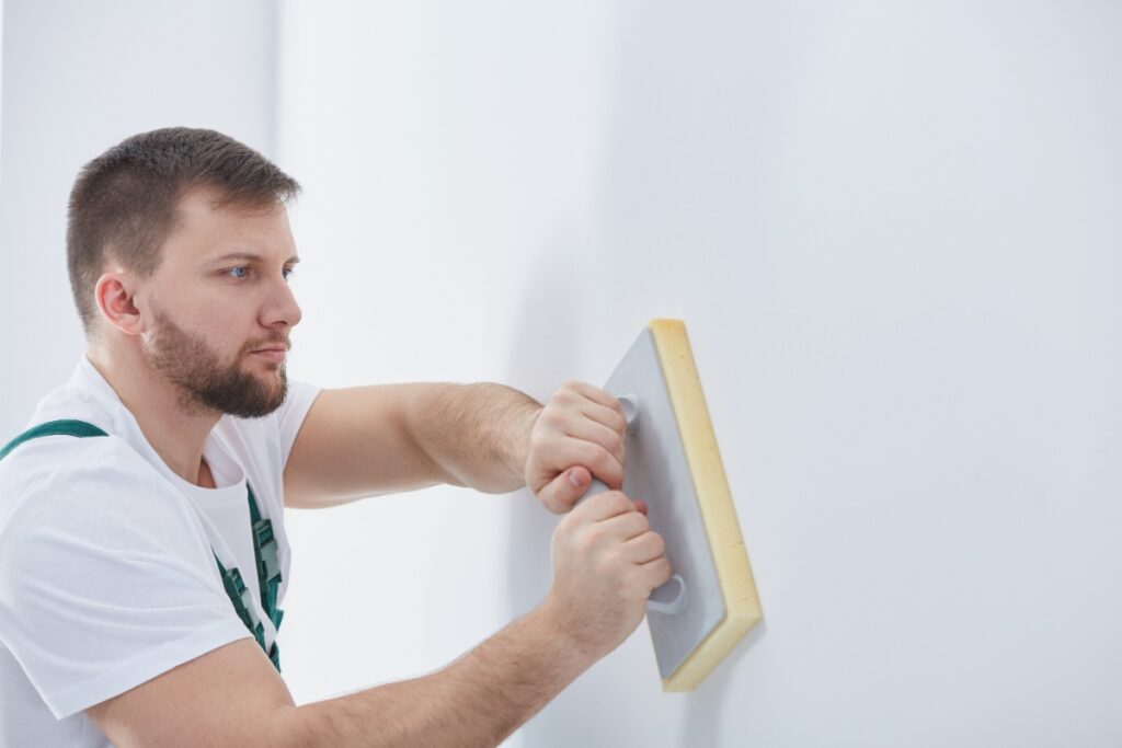 Un homme lissant le mur intérieur
