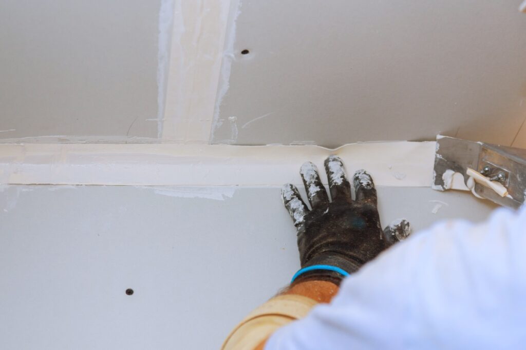 Un ouvrier lissant le joint de plaques plâtre