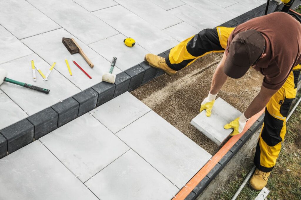 Un ouvrier posant du carrelage sur une terrasse