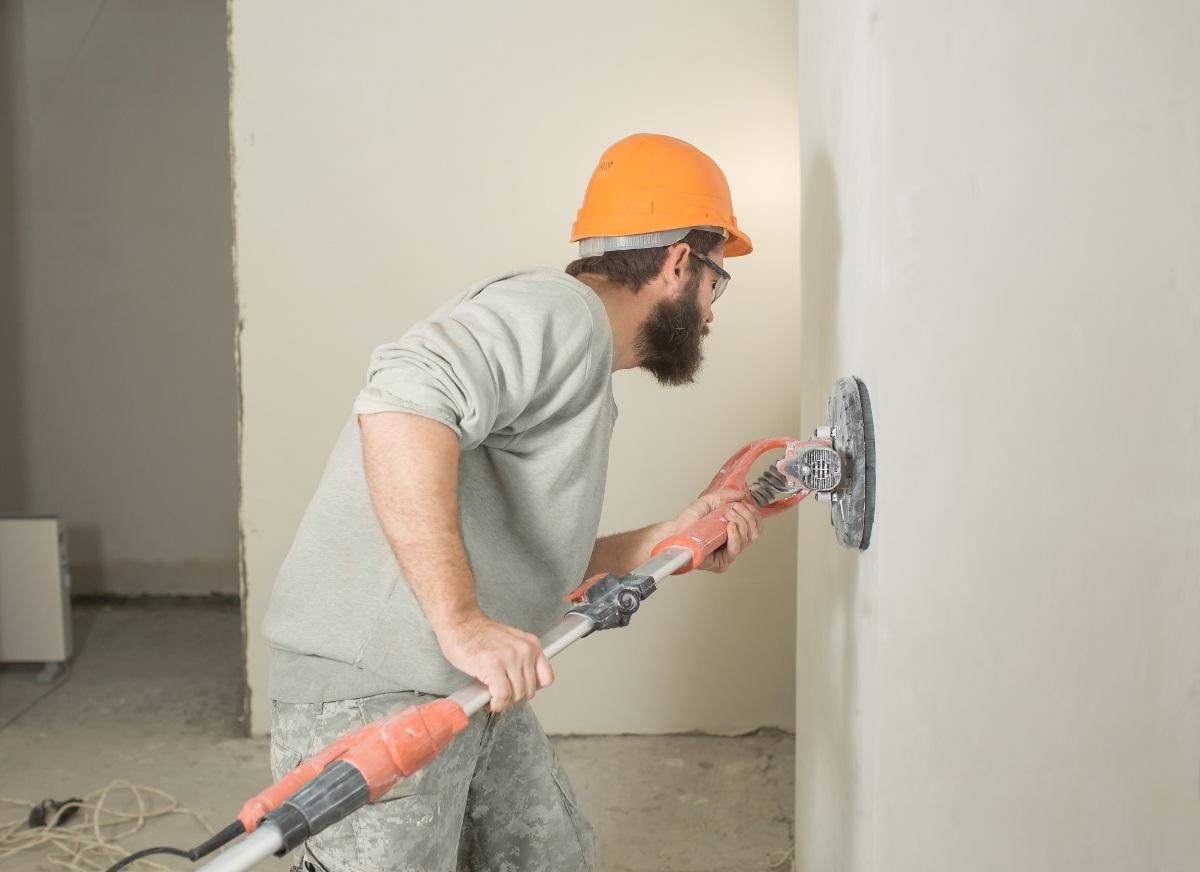 Un ouvrier qui prépare le mur pour une pose de plaque plâtre