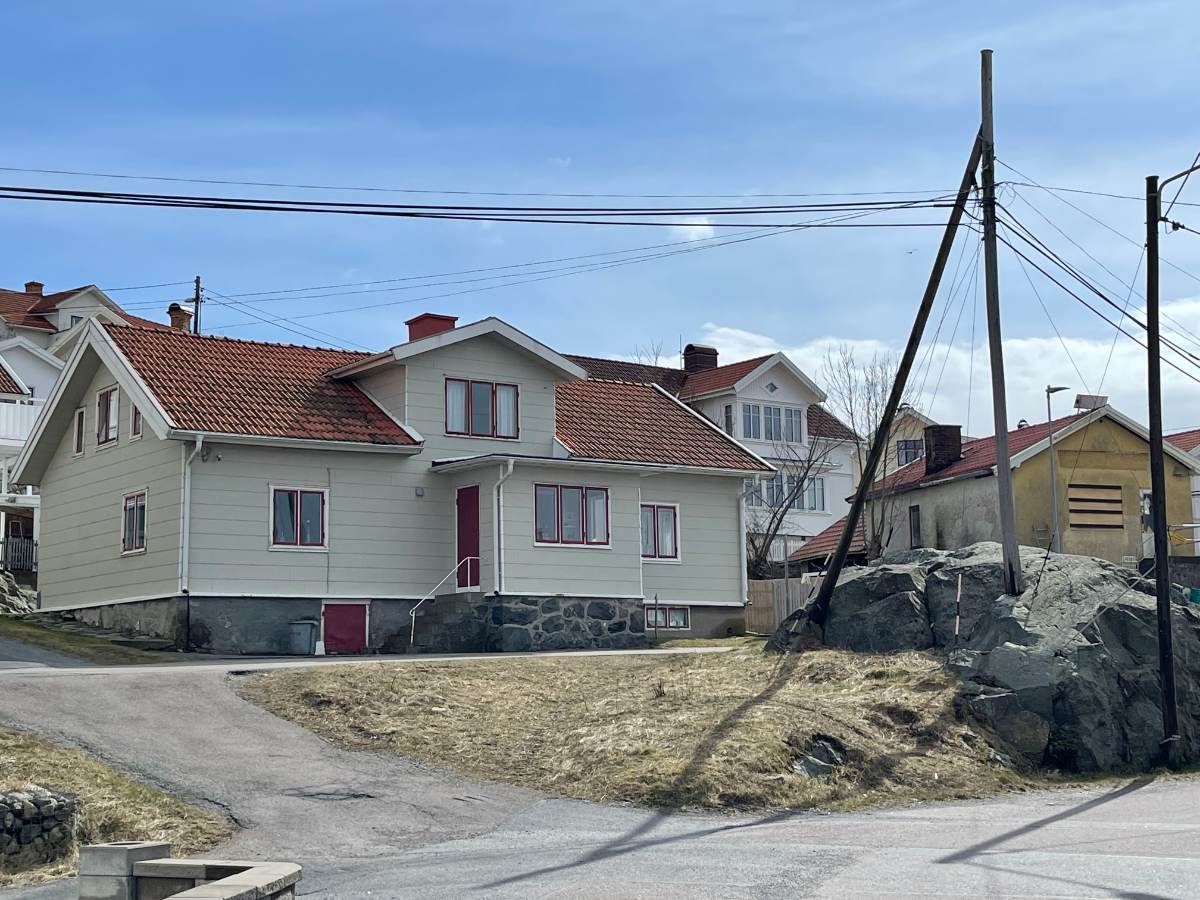 Poteau avec lignes éléctriques devant une maison