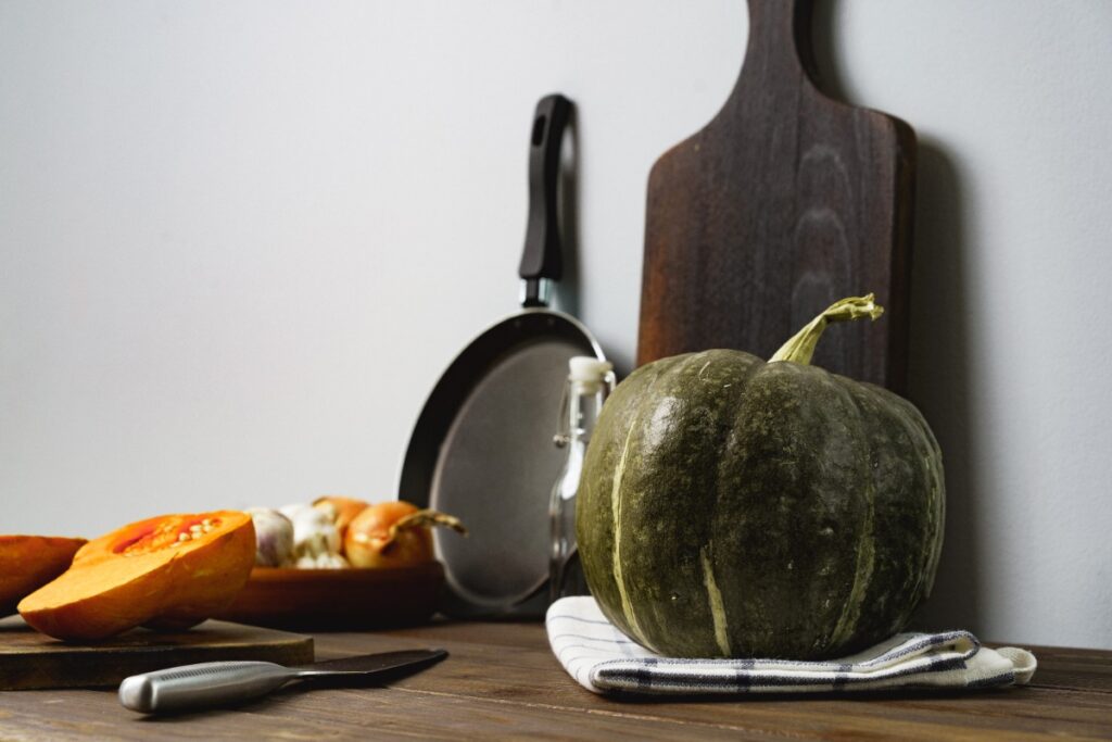 Un potiron placé avec des ustensiles de cuisine