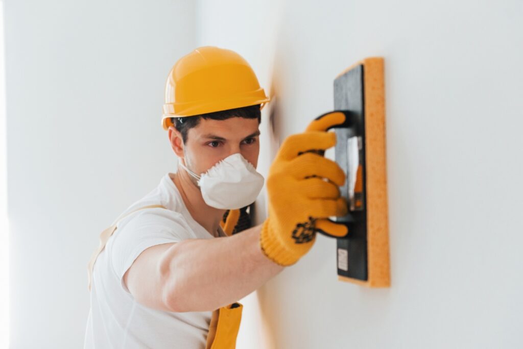 Un professionnel qui lisse le mur