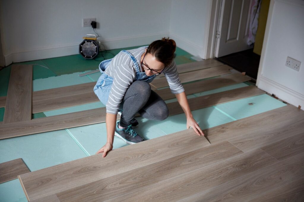 Une femme installant du nouveau plancher