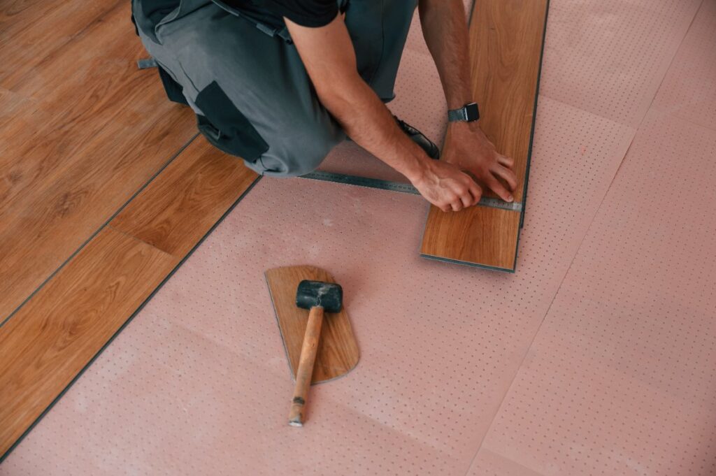 Un homme installant un nouveau parquet