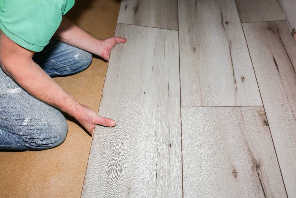 Un homme posant du lino sur le parquet