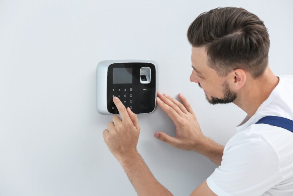 Un homme programmant un système de sécurité dans une maison