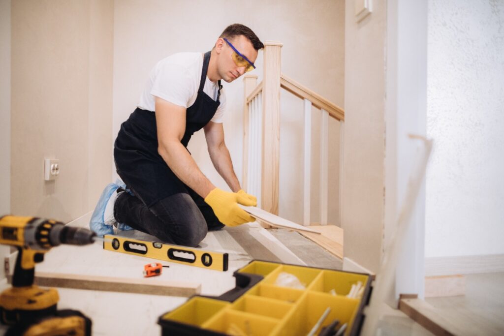 Un professionnel installant du parquet dans une maison