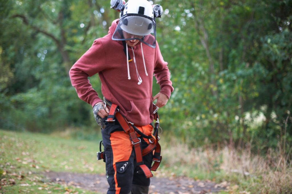 Un arboriste portant des équipements de sécurité dans la forêt