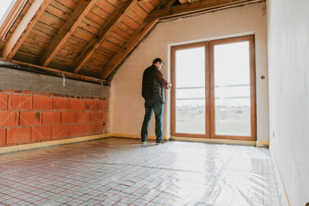 Un homme inspectant l'état du mur intérieur d'une maison