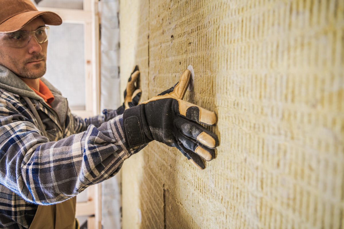Un homme posant un isolant sur le mur