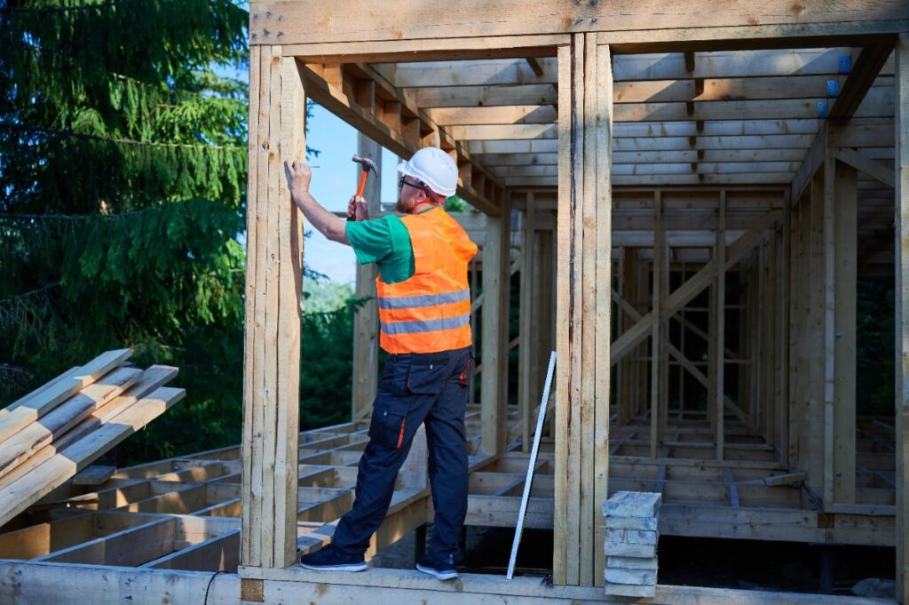 Un charpentier qui enfonce du clou sur du bois