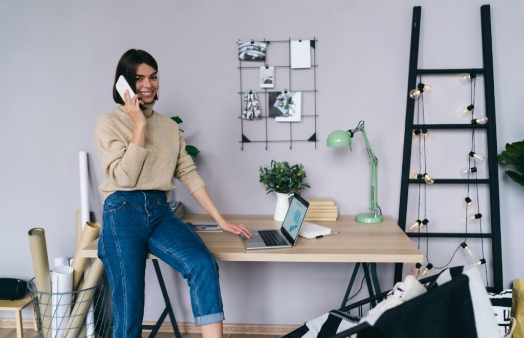 Une femme souriante parlant au téléphone dans son bureau
