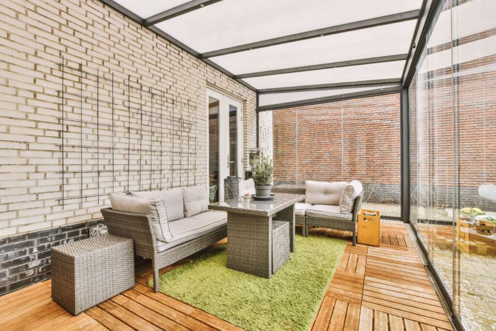 Une pièce vitrée dans le jardin avec des meubles